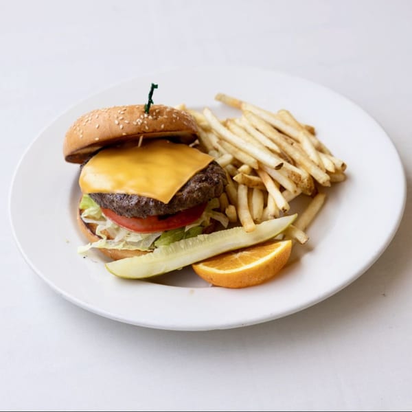 Effie's Restaurant & Bar's cheeseburger with fries, a pickle spear, and an orange slice on a white plate.
