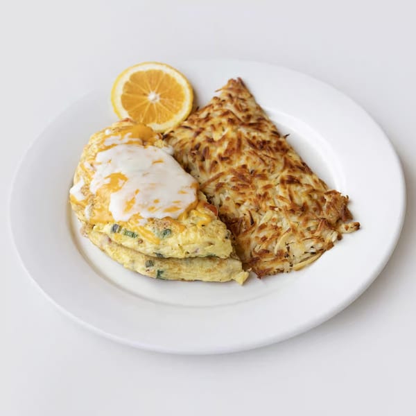 Effie's breakfast plate with a cheesy omelet, crispy hash browns, and an orange slice.